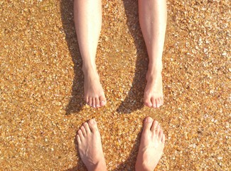 Male and female foot on the beach