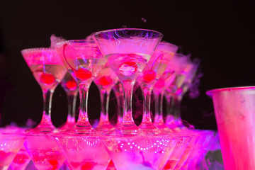 Cocktail with cherry and dry ice on dark background