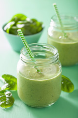Obraz na płótnie Canvas healthy green smoothie with spinach mango banana in glass jars