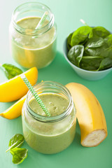 healthy green smoothie with spinach mango banana in glass jars