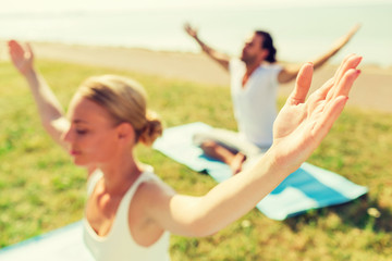 close up of couple making yoga exercises outdoors