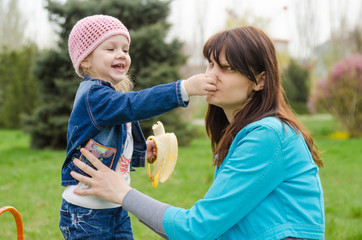 Girl with banana mother pinched nose