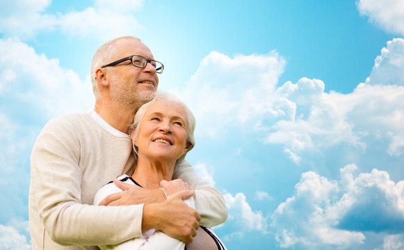 happy senior couple over blue sky and clouds