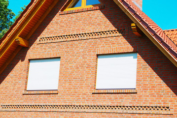 Fenster mit heruntergelassenen Jalousien zum Schutz vor der Sonneneinstrahlung.