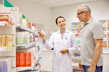 pharmacist showing drug to senior man at pharmacy