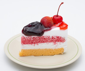 Piece of cake with fresh fruit isolated on white background.