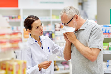 Fototapeta na wymiar pharmacist and senior man with flu at pharmacy