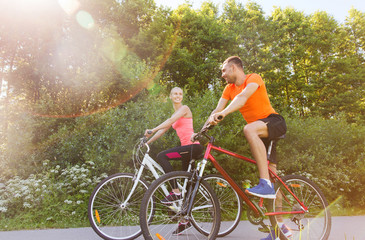 Plakat happy couple riding bicycle outdoors