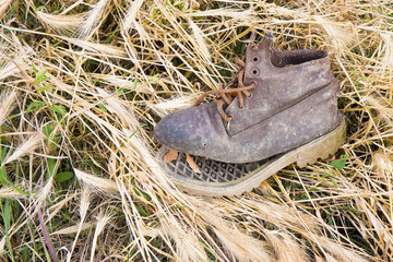Old broken boot abandoned in a grass carpet