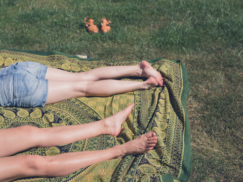 Legs of two young women outside on grass