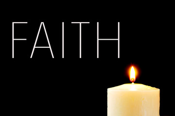 a lit candle and the word faith