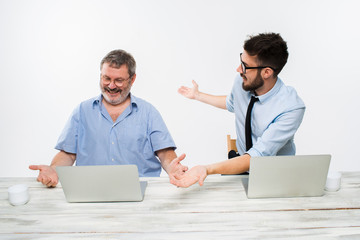 The two colleagues working together at office on white