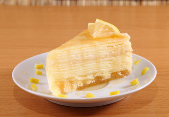 Lemon crepe cake with honey on plate.