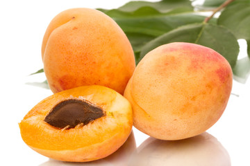 Ripe apricots and half on a white background