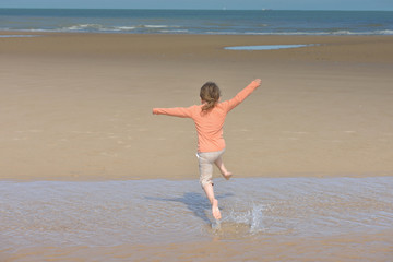 enfant courant, sautant sur la plage