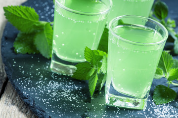 Green cocktail with rum, mint, soda and sugar, selective focus
