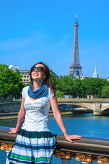 Happy travel girl on the Pont Alexandre III bridge with Eiffel Tower in Paris