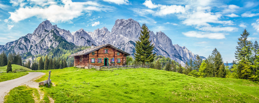Idyllic landscape in the Alps with mountain chalet and green meadows