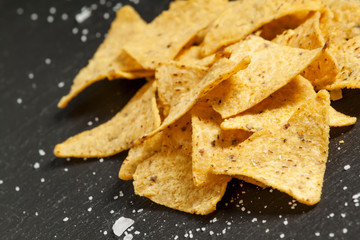 Nachos and salt on a dark background, selective focus