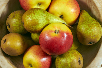 Apples and pears in a wooden bowl.