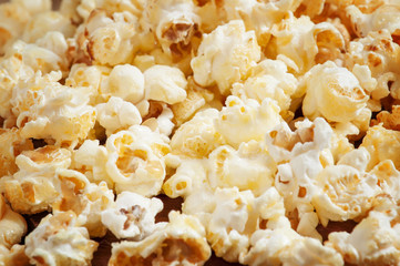 Sweet caramel popcorn in a wooden bowl, selective focus
