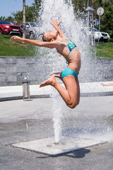 Счастливая девочка под фонтаном