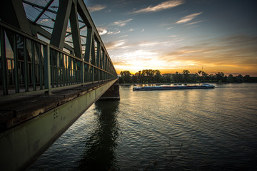 Transportschiff an der Kaiserbrücke am Rhein im Sonnenaufgang