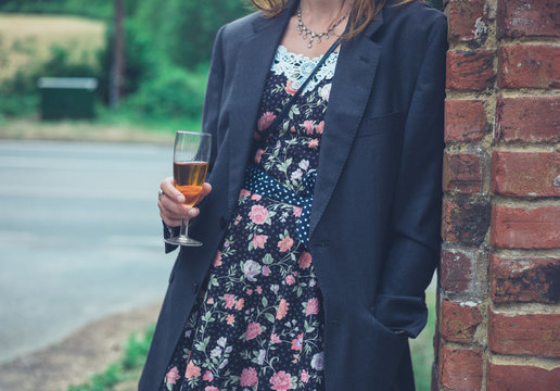 Young woman wearing jacket and drinking wine