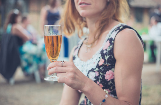 Woman with drink at party outside