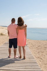 Back view of a young couple at the ocean