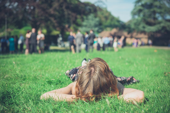 Woman relaxing on grass at party