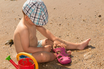 Cute baby boy playing with beach toys