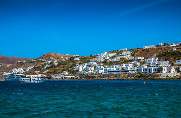 Greek island with colorful houses and yachts.