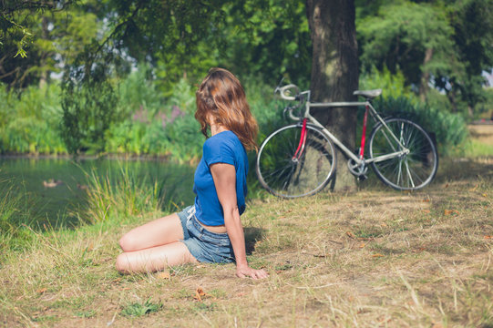 Young woman relaxing by water in the park