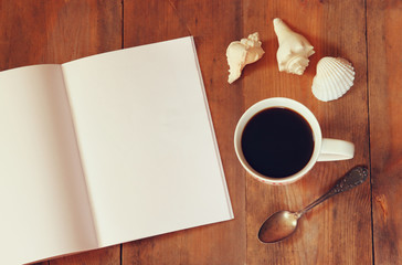 top view image of open notebook next to cup of coffe