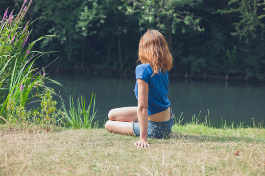 Young woman relaxing by water in park