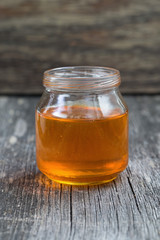 flavored honey in a glass jar on wooden background