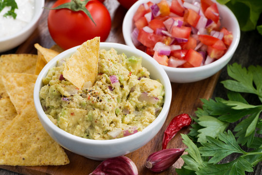guacamole sauce, tomato salsa and corn chips, top view