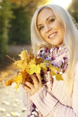 Attractive woman in summer with autumn leaves