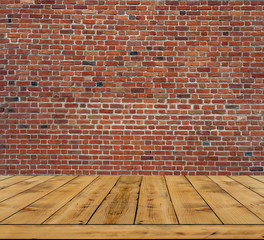 Textured old red brick wall with wooden floor inside