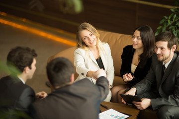 A diverse attractive man and woman business team handshake at office building