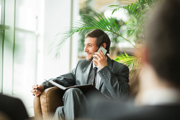 Confident businessman in office talking on the phone.