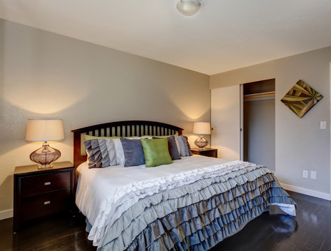 Perfect hardwood bedroom with ruffled bedding.