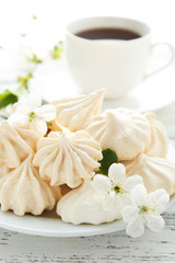 French meringue cookies on plate on white wooden background