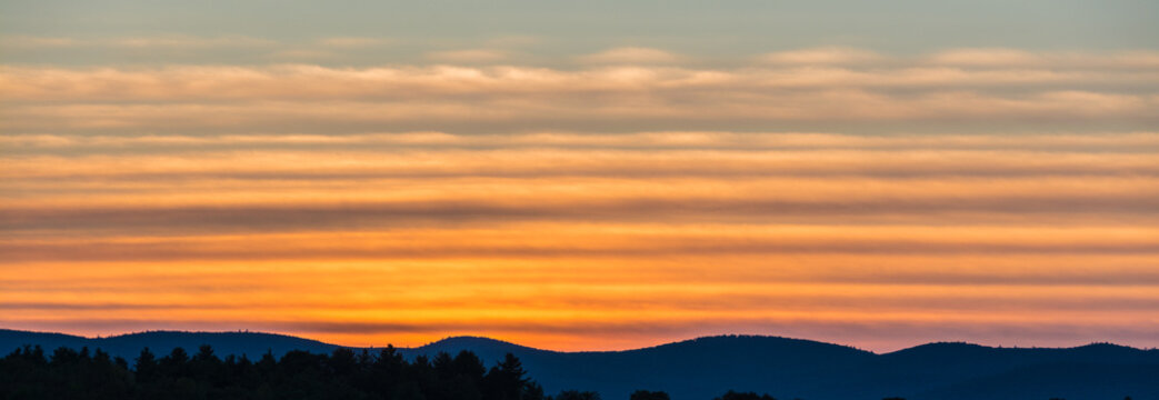 Mountains Of The Adirondacks Silhouetted Against A Golden Sunset.   