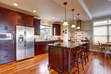 State of the art kitchen with deep stained wood.