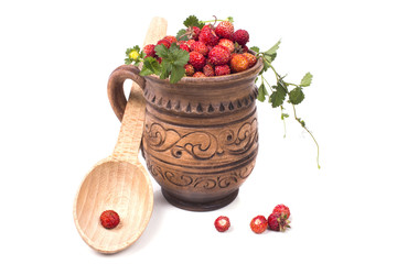 fresh strawberries in a clay mug with a wooden spoon