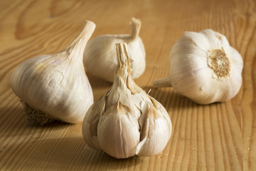 Garlic bulbs and cloves on wooden table, closeup