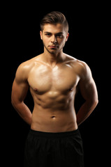 Fototapeta premium Muscle young man on dark background