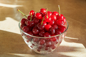 glass bowl full of wet red ripe cherries